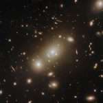 Hubble Sees Cluster Of Galaxies, Some Distorted By Gravity